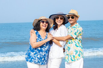 Portrait of happy senior indian family enjoying summer holidays vacations at beach, Retired senior tourist couple with young daughter having fun travel together outdoor. 