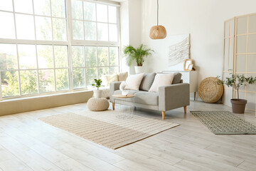 Wall Mural - Interior of light living room with grey sofa, houseplants and coffee table
