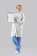 © Pixel-Shot - Female doctor with clipboard on light background