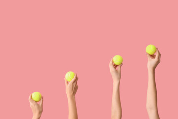 Wall Mural - Female hands with tennis balls on pink background