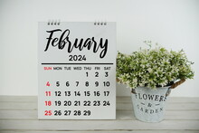 February 2024 Monthly Calendar With Vintage Alarm Clock On Wooden Background