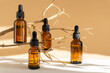 Serum in amber-colored glass vials with dropper lid on brown background. Essential oil for care of women's skin in rays of sunlight. Concept of beauty, rejuvenation, mockup.