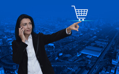 Wall Mural - Businesswoman hand pressing shop cart icon over modern city tower, street, expressway and skyscraper, Business shopping online concept