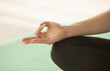 © lashkhidzetim - Close up of hands young woman working out on fitness mat, doing lotus yoga pose at the gym. Yoga exercise, relax and meditating, copy space.