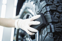 Professional Car Service Worker Polishing Car Tires With Black Sponge
