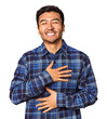 © Asier - Young Chinese man in studio background laughs happily and has fun keeping hands on stomach.
