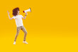 Happy preteen boy shouting into megaphone making announcement. Full length portrait of happy boy in white shirt and jeans holding megaphone screaming into empty space over isolated background