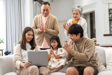 Wall Mural - Father and mother with asian kid girl learn on laptop computer reviewing lesson study with online education e-learning.student look for educational knowledge in homeschool at home.Education