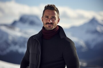 Wall Mural - Portrait of a content man in his 30s wearing a classic turtleneck sweater against a snowy mountain range. AI Generation