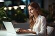 © visoot - Woman in white shirt typing at laptop on the table in a modern office.