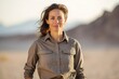 © CogniLens - Portrait of a tender woman in her 40s sporting a breathable hiking shirt against a serene dune landscape background. AI Generation