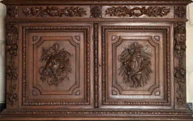 Old vintage wardrobe furniture with ornamental doors and retro colors of wooden surfaces close up