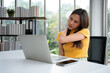 © Prot - Beautiful young Asian businesswoman, shoulders and back pain during work long time on workplace. Body muscles stiff problem after long day work and overworked. Office syndrome and Healthcare concept.
