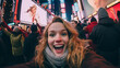 Stylish Happy Woman Takes a Selfie Against the Exciting Backdrop of Times Square Crowd in Manhattan, New York City.