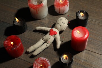 Wall Mural - Voodoo doll with pins in circle of burning candles on wooden table