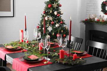 Poster - Elegant Christmas table setting with dishware and burning candles in festively decorated room