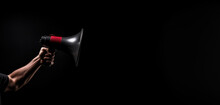 Single Hand Holds A Megaphone Against A Pitch Black Background