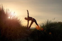Silhouette Sporty Woman Doing A Triangle Yoga Pose At Sunrise