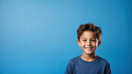 Wall Mural - Boy smile isolated in bright blue background, backdrop with copy space