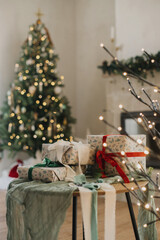 merry christmas and happy holidays! stylish wrapped christmas gifts with ribbon on table on backgrou
