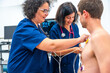 © unai - Cardiologist placing electrodes on a patient for a stress test