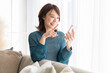 © miya227 - 部屋でスマホを見る若い女性