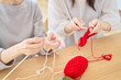 編み物をするシニア女性と若い女性の手元