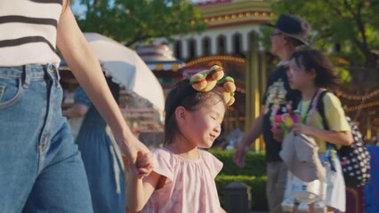 Wall Mural - Asian mother and young daughter traveling in the theme park together. 