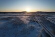 The winter sun hangs low over a quiet, snow-laden road in Krokvik.