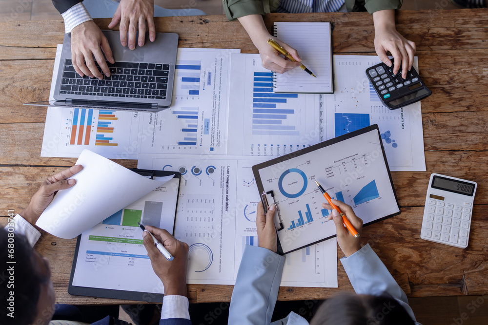 Group of confident business people point to graphs and charts to ...