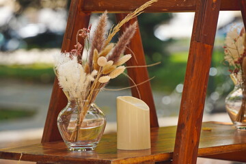 Wall Mural - A vase with dried flowers on a wooden shelf.