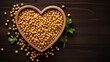 Chickpeas in a bowl in the shape of a heart on a wooden background.