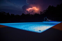 Illuminated Swimming Pool With Thunderstorm At Night