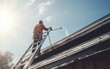 side view of Worker standing on ladder and cleaning house metal roof 