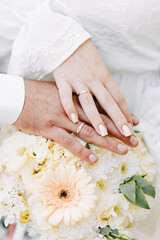 Newlyweds exchange rings, groom puts the ring on the bride's hand.