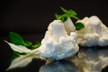 Canvas Print - slices of raw small raw cauliflower on black background