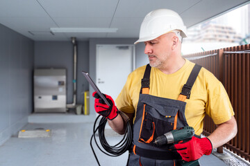 Poster - electrical engineer. man with wire and screwdriver. worker stands in engineering room. electrician u