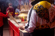 Chinese people celebrating traditional Chinese New Year in Chinese temple, they burning incense and praying, holiday concept