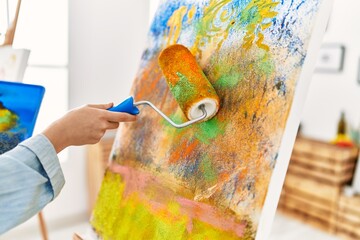 Poster - Young caucasian woman artist using paint roller drawing at art studio