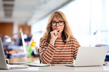 Sticker - Blond haired businesswoman using laptops for work at the office