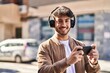 © Krakenimages.com - Young hispanic man smiling confident playing video game at street