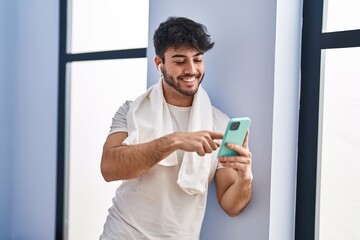 Poster - Young hispanic man smiling confident using smartphone at sport center