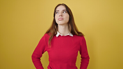 Canvas Print - Young hispanic woman standing with serious expression over isolated yellow background