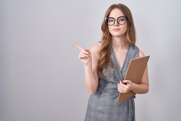 Poster - Caucasian woman wearing glasses and business clothes pointing with hand finger to the side showing advertisement, serious and calm face