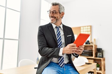 Wall Mural - Middle age grey-haired man architect smiling confident using touchpad at office