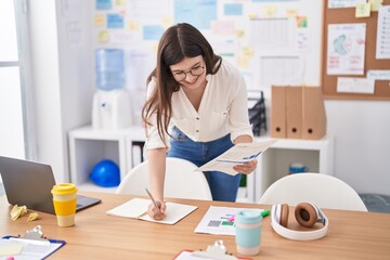 Wall Mural - Young caucasian woman business worker writing on document at office