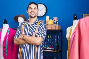 Sticker - Young hispanic man tailor smiling confident standing with arms crossed gesture at sewing studio