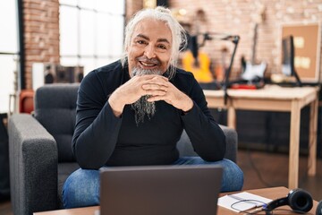 Sticker - Middle age grey-haired man musician using laptop sitting on chair at music studio