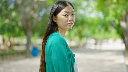 Sticker - Young chinese woman standing with serious expression at park