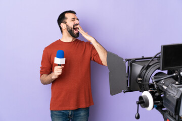 Wall Mural - Reporter man holding a microphone and reporting news over isolated purple background yawning and covering wide open mouth with hand